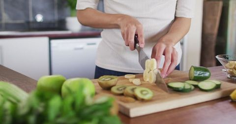 Woman Slicing Fresh Fruits in Modern Kitchen