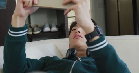 Teen Relaxing at Home Playing Games on Tablet