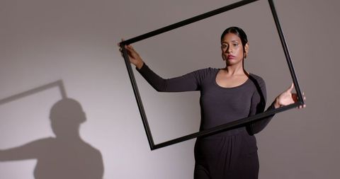 Monochrome elegance: woman aligns picture frame