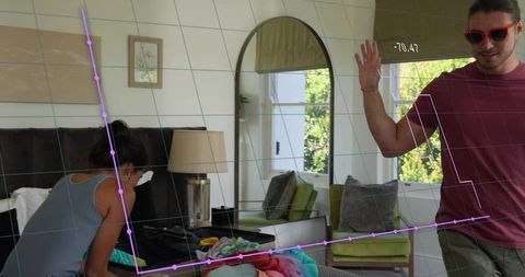 Couple packing clothes in bright bedroom with augmented reality tracking overlay