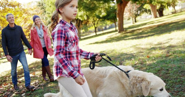 Family Enjoying Leisure Stroll with Daughter Guiding Golden Retriever in Park - Download Free Stock Images Pikwizard.com