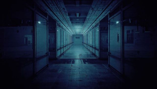 Futuristic lab corridor with glass panels and reflective floor leading to vanishing point