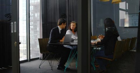 Professionals Collaborating on Project in Modern Conference Room