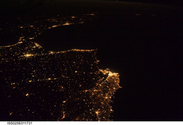 This nighttime aerial view captures the beautifully illuminated Atlantic coastline from Lisbon, Portugal, extending south across the Strait of Gibraltar to Casablanca, Morocco. The brightly lit cities contrast perfectly with the dark surroundings, creating a spectacular visual. This image can be used for educational purposes, travel promotions, articles on geographic and cultural connections between Europe and Africa, and space exploration content.