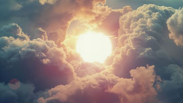 Glowing sun between illuminated cumulus clouds in open sky