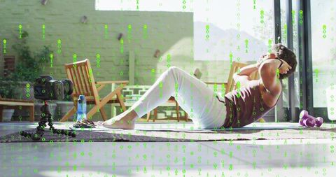 Man doing crunches on mat by sliding doors with dslr recording home fitness routine