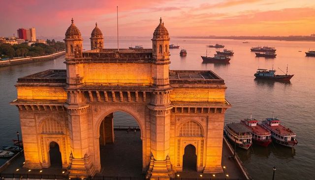 Gateway of india at sunset with moored boats and golden light