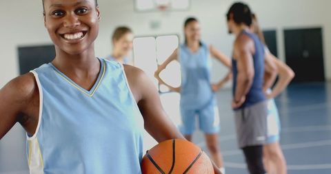 Confident Female Basketball Player Holding Ball on Court