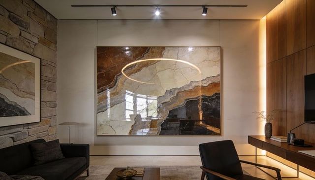 Large framed abstract marble artwork reflecting ring light in minimalist living room