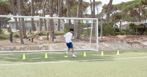 Boy Practicing Soccer Dribbling Drills on Synthetic Field