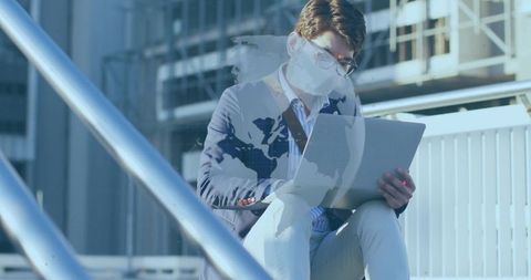 Businessman Using Laptop on Metal Steps in Urban Setting