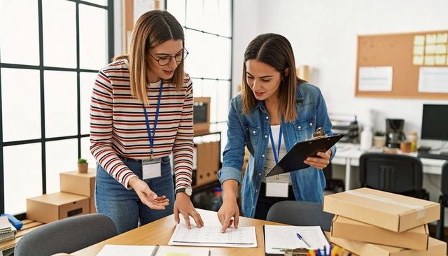 Women planning order fulfillment schedule in small business packing and logistics hub