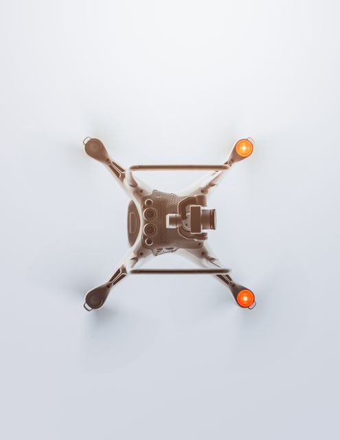 Provides a precise overhead view of a modern drone equipped with red indicator lights and cutting-edge technology. Use for technology showcases, innovation promotional materials, or drone enthusiast content.