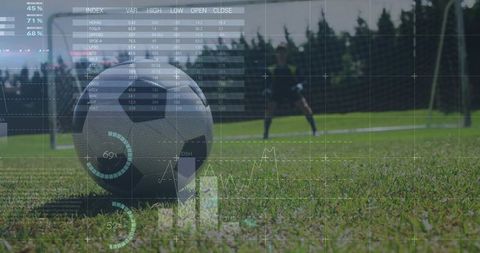 Soccer ball resting on grass with goalkeeper preparing shot and AR analytics overlay