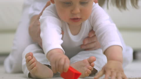 Careful Toddler Grasping Colorful Toy on Soft Carpet