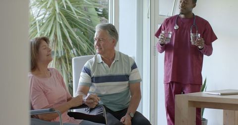 Elderly Couple Sharing Moment Caregiver Provides Support at Home