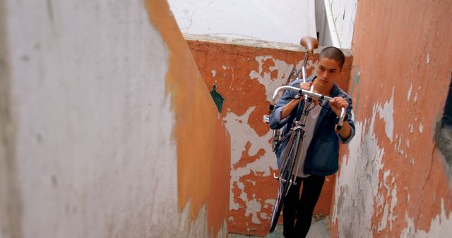 Young Man Carrying Bicycle through Narrow Alleyway - Download Free Stock Images Pikwizard.com