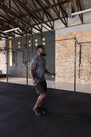African american man jumping rope in industrial gym for cardio and functional fitness