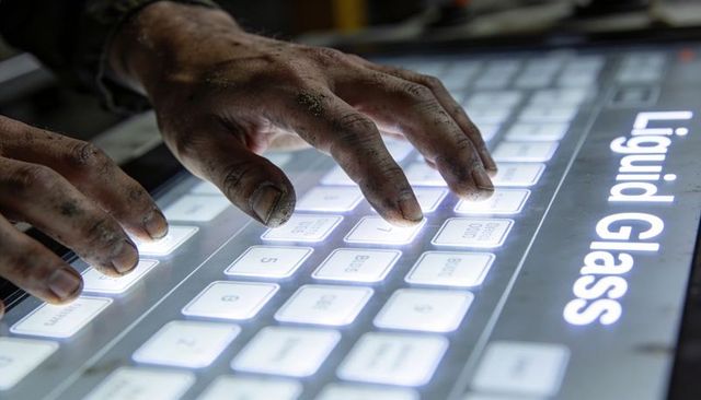 Grimy hands pressing backlit touchscreen keyboard with liquid glass label, industrial tech