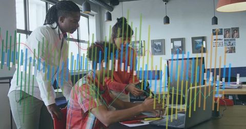 Young team collaborating around laptop with data visualization overlays in modern office