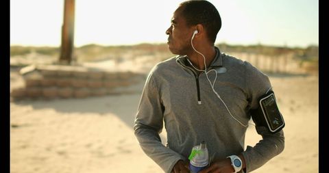 Athletic Man Jogging at Beach with Smartwatch Technology - Download Free Stock Images Pikwizard.com