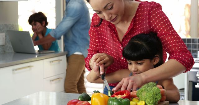 Mother helping daughter chop vegetables in kitchen - Download Free Stock Images Pikwizard.com