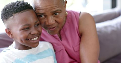 Loving Grandmother Embracing Smiling Grandson on Sofa