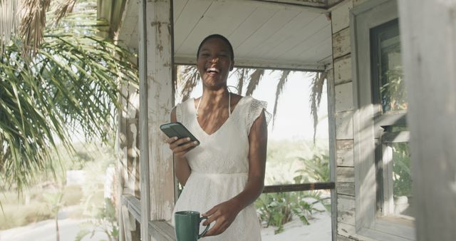 Smiling Woman Enjoying Coffee and Using Smartphone Outdoors - Download Free Stock Images Pikwizard.com