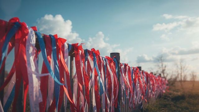 Colorful Ribbons Adorning Wooden Fence in Scenic Countryside