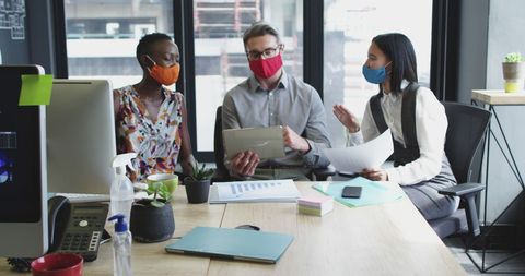 Diverse Business Team Collaborating with Tablets and Masks in Modern Office - Download Free Stock Images Pikwizard.com