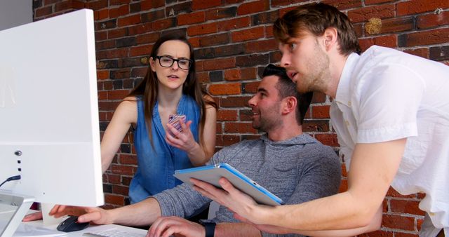 Collaborative Team Working on Project in Office with Brick Wall - Download Free Stock Images Pikwizard.com