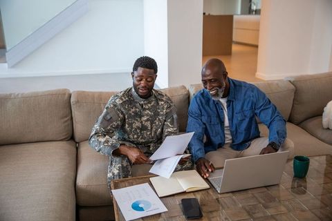 African American Father and Son Reviewing Financial Charts at Home