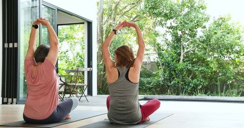 Senior and Adult Daughter Practicing Yoga Together Outdoors