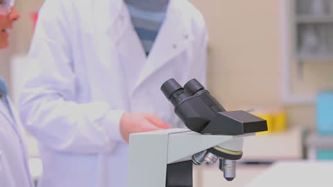Scientists Conducting Research in Laboratory with Microscope