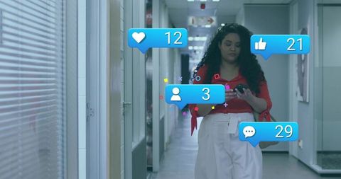 Businesswoman walking office corridor checking smartphone with social notifications