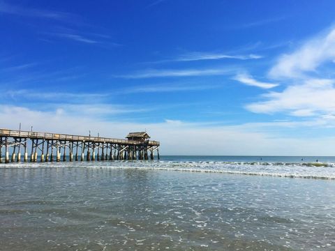 Peaceful Beach with Wooden Pier Extending into Ocean