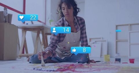 Creative artist engaging with art and social media in studio