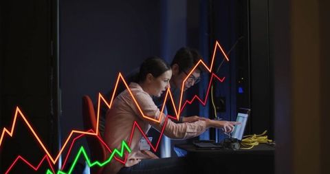 It professionals analyzing data displaying rising graphs in control room