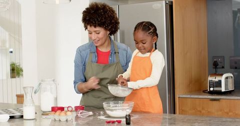 Mother and Daughter Bonding While Baking Together in Kitchen