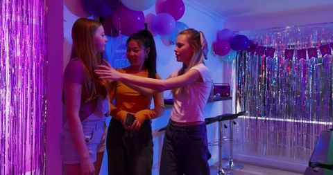 Multicultural Teen Girls Celebrating Birthday with Purple Balloons and Shimmering Fringe