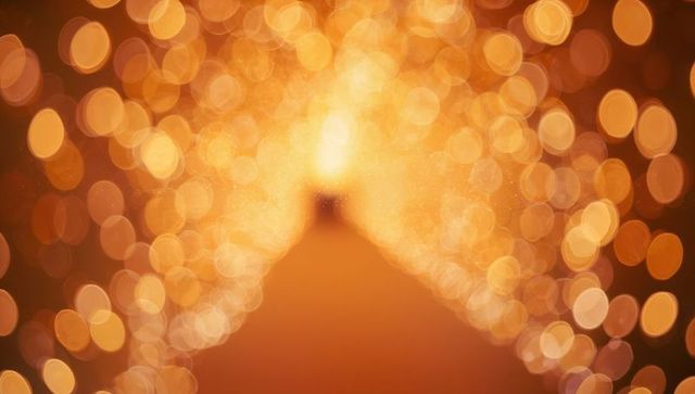 Golden bokeh tunnel glowing with warm fairy lights converging to bright center festive backdrop
