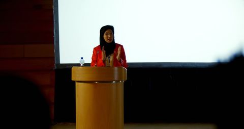 Hijab Businesswoman Presenting at Auditorium Podium