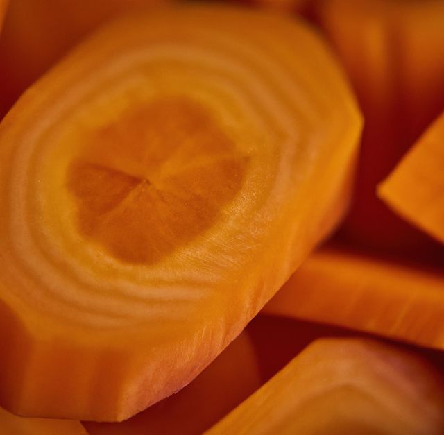 Image shows close-up view of sliced carrots with detailed texture and vibrant orange color. Suitable for use in health and nutrition articles, cooking blogs, vegan and vegetarian recipes, menus, or promotional material for organic produce. Emphasizes freshness and natural quality of ingredients.