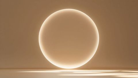 Glowing orb casting reflections in minimalist beige space