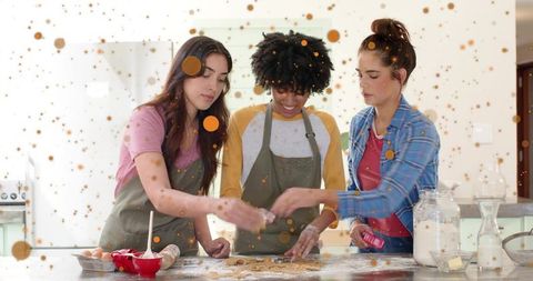 Three women baking and shaping cookies on kitchen island, flour-covered fun