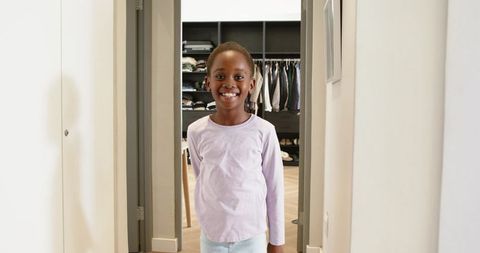 Happy Child Standing in a Cozy Modern Home Hallway