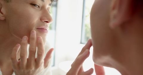 Man Enjoying Morning Skincare Routine in Bathroom