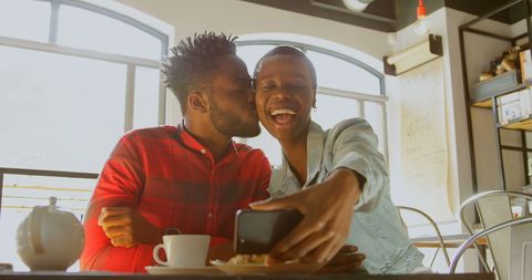 Cheerful couple at cafe capturing happy selfie moment