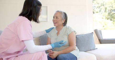 Nurse comforting senior patient during home healthcare visit