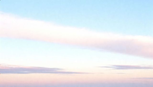 Pastel dawn gradient sky with soft pink cloud band over distant horizon
